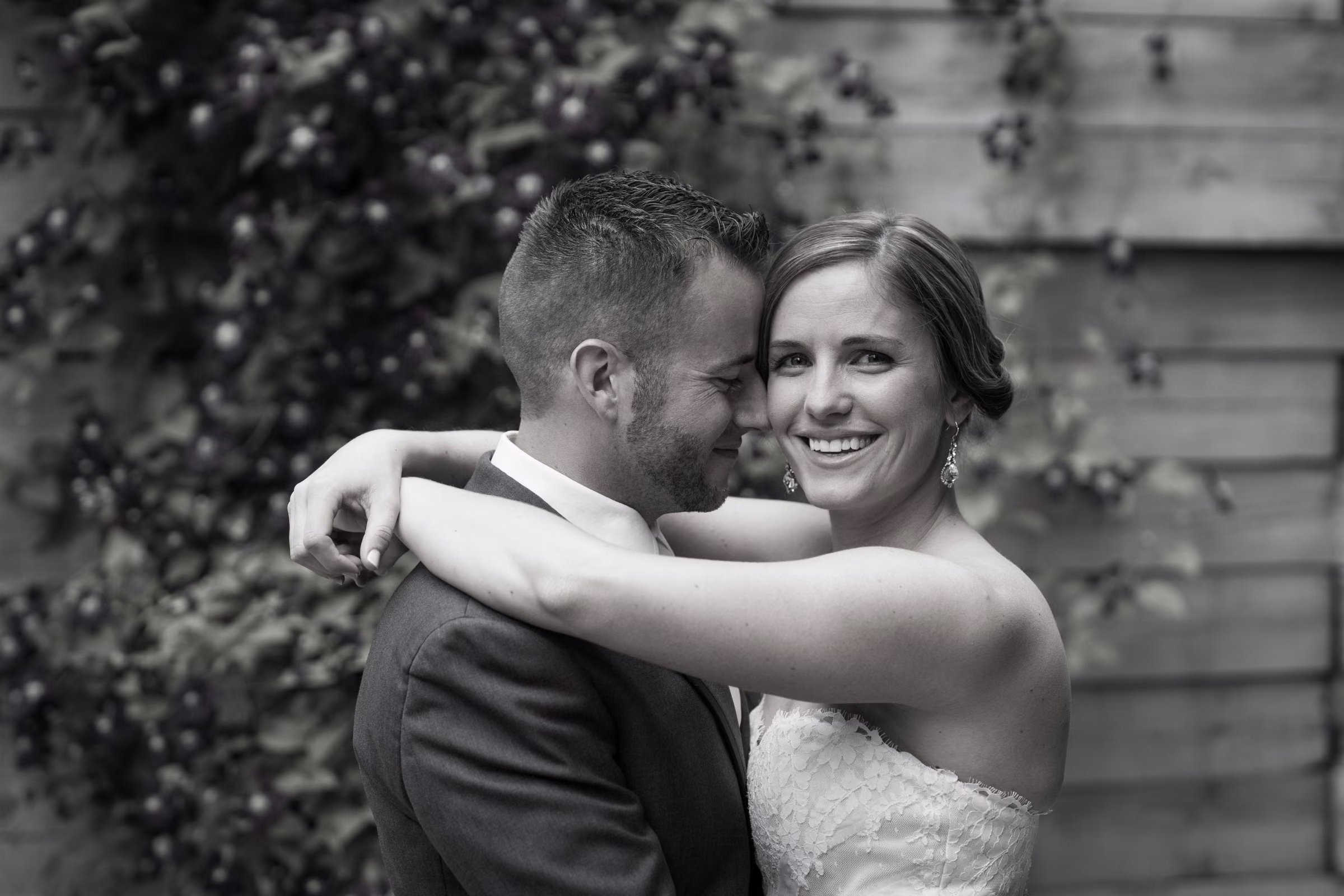 Annie smiles as she embraces Matt in a black and white portrait after their first look