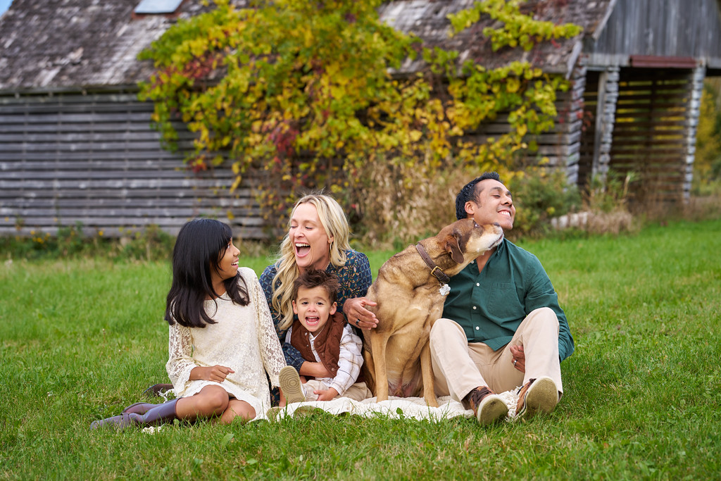 Carrie laughing as Vicky reacts to the pregnancy announcement during their family portrait at Minnesota Landscape Arboretum, Chaska, Minnesota
