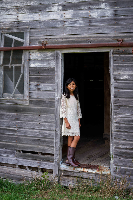 Vicky Zaragoza standing in a weathered barn doorway at Minnesota Landscape Arboretum, Chaska, Minnesota